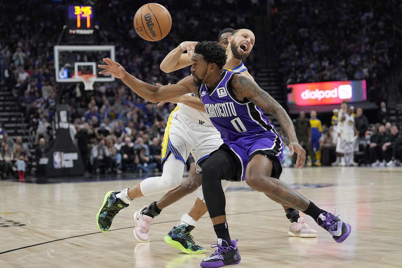 Steph Curry and Malik Monk colliding while the basketball goes flying. 