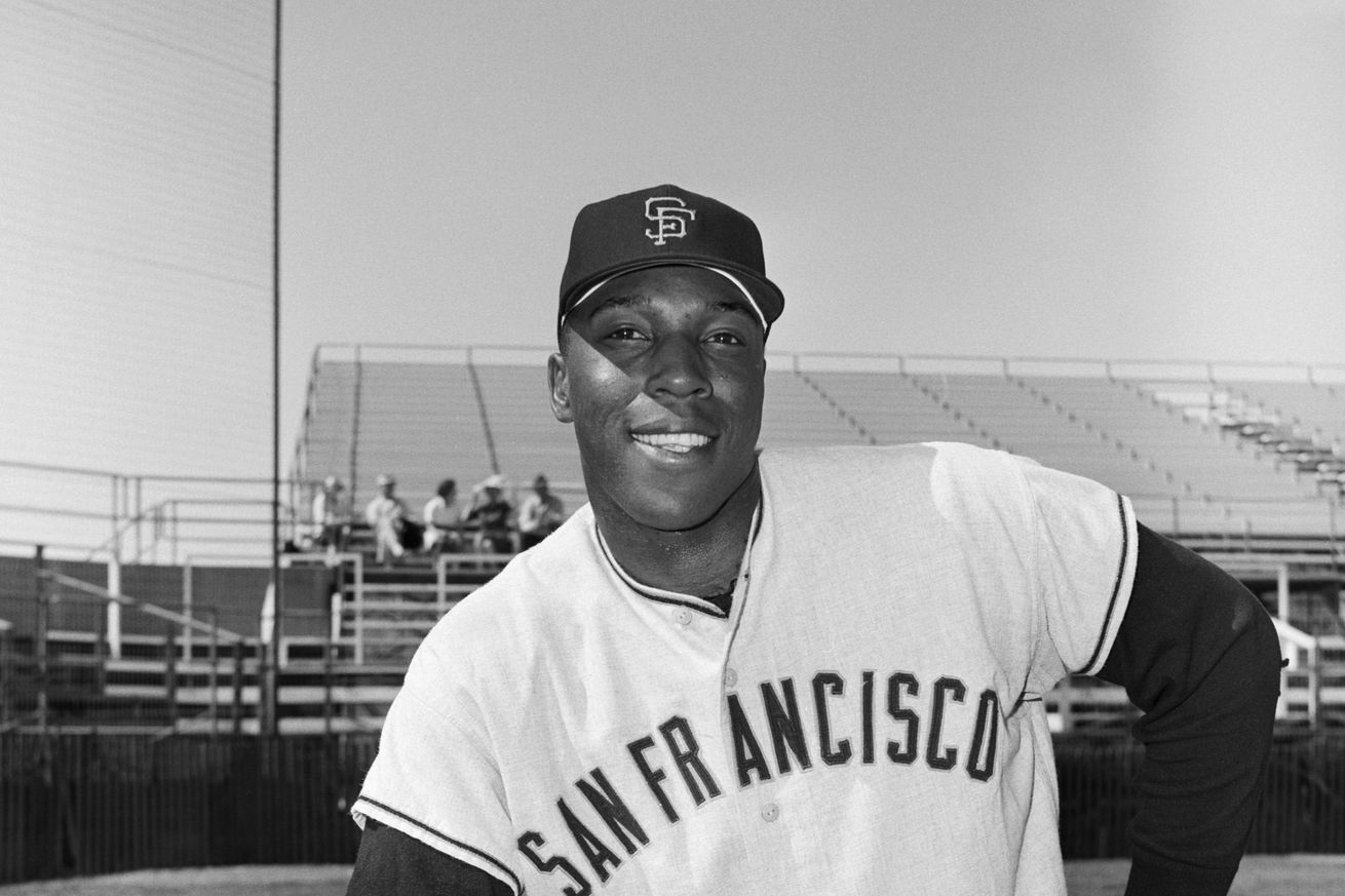 Black and white picture of Willie McCovey leaning on one knee. 