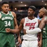 Miami Heat forward Jimmy Butler (22) stands between Milwaukee Bucks forwards Giannis Antetokounmpo (34) and Khris Middleton (22)