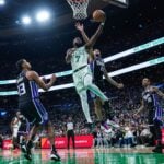 Jan 10, 2025; Boston, Massachusetts, USA; Boston Celtics guard Jaylen Brown (7) shoots against Sacramento Kings guard Devin Carter (22) in the second half at TD Garden.