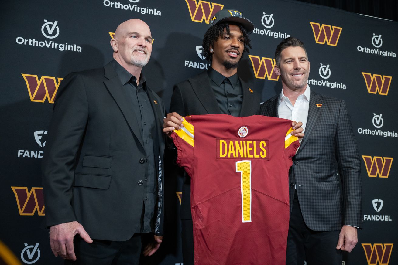 ASHBURN, VA - APRIL 26: Quarterback Jayden Daniels poses with C