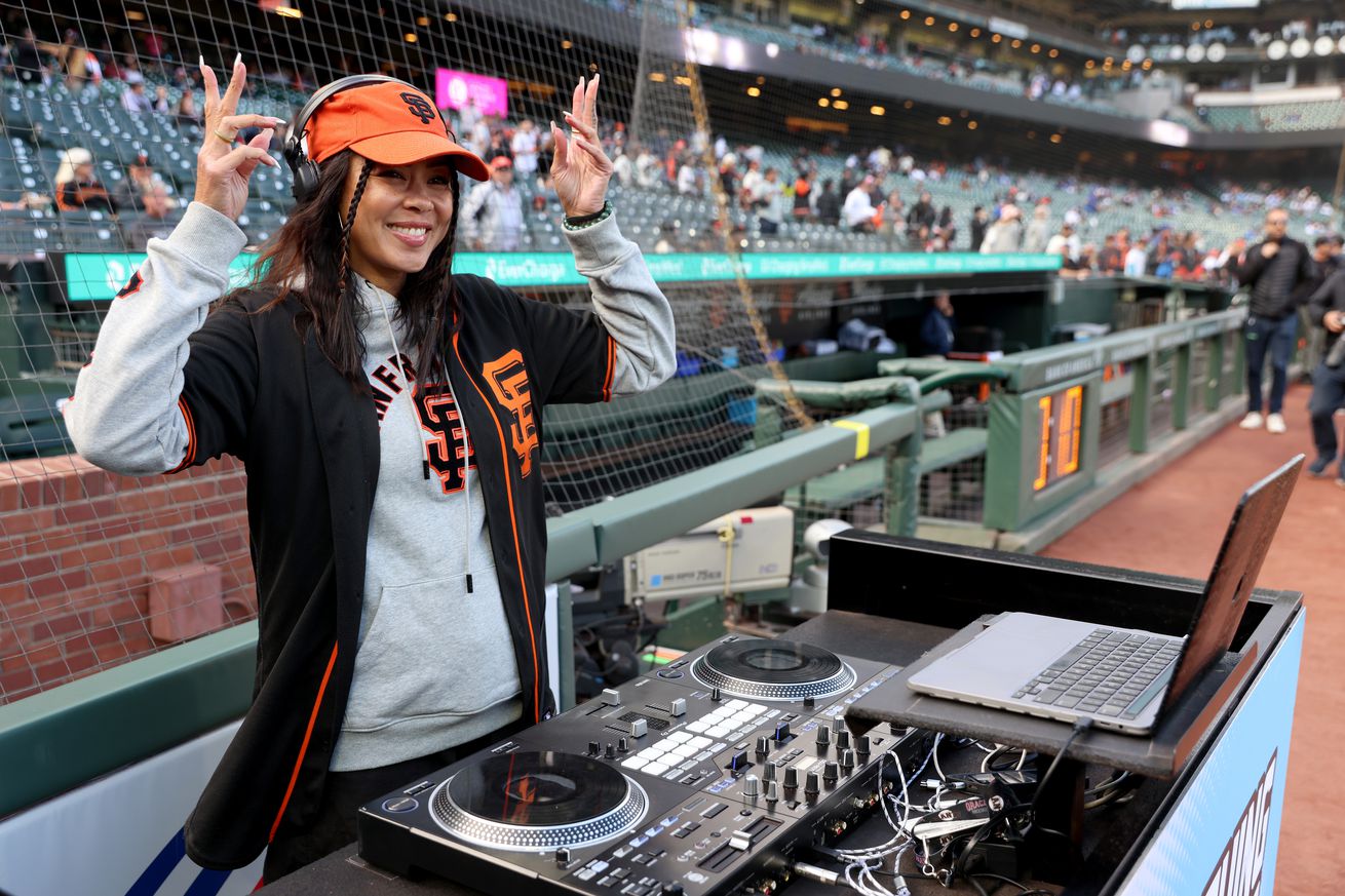 DJ Umami in Giants gear playing music at Oracle Park. 