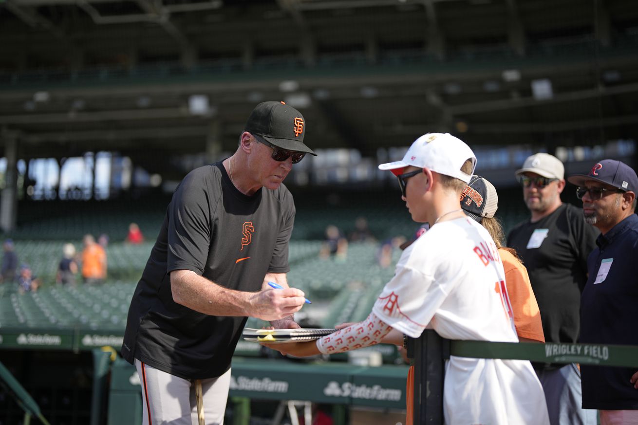 Bob Melvin signing autographs for a young fan. 