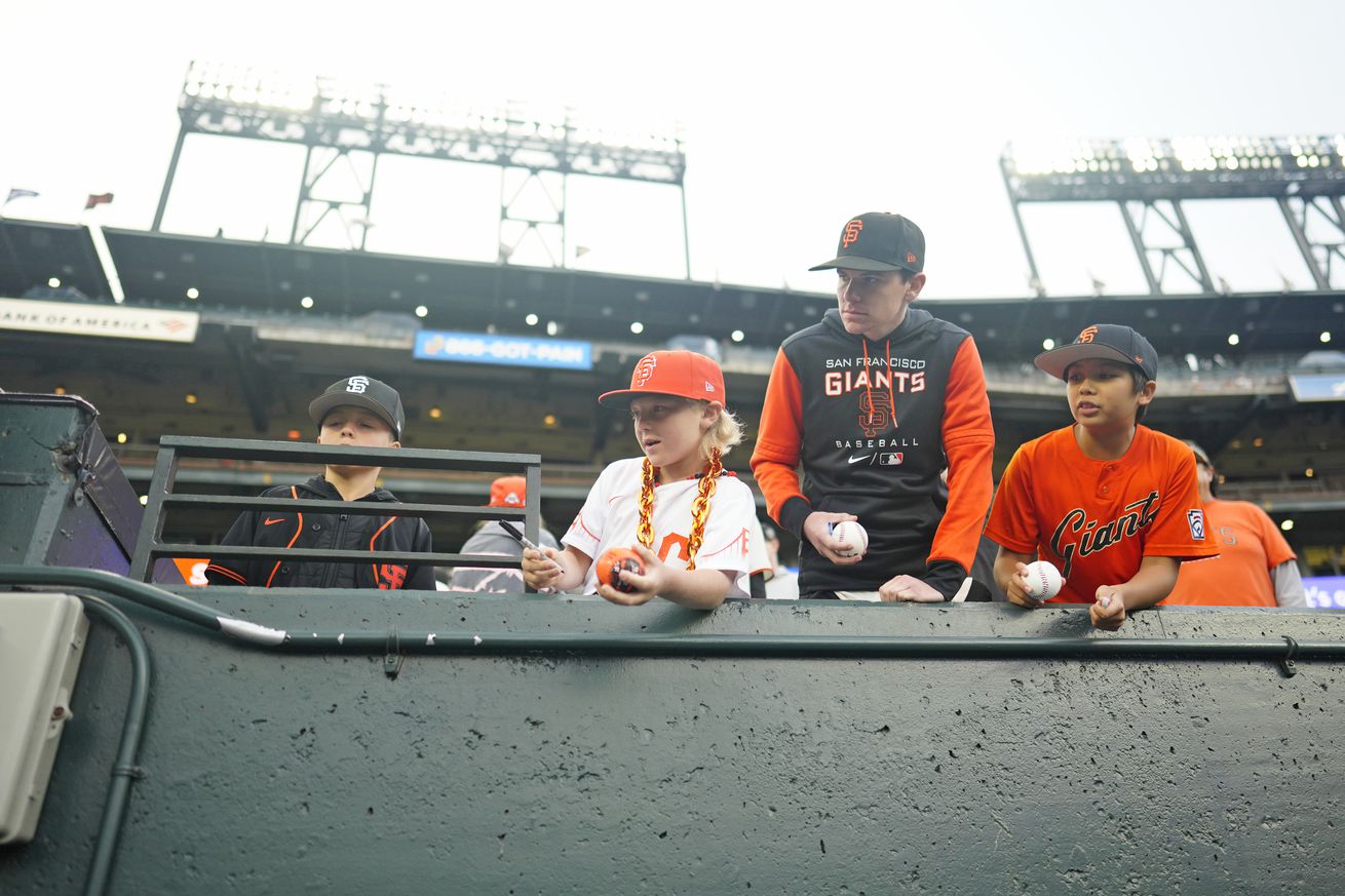 Three kids in Giants shirts hanging out in the seats. 