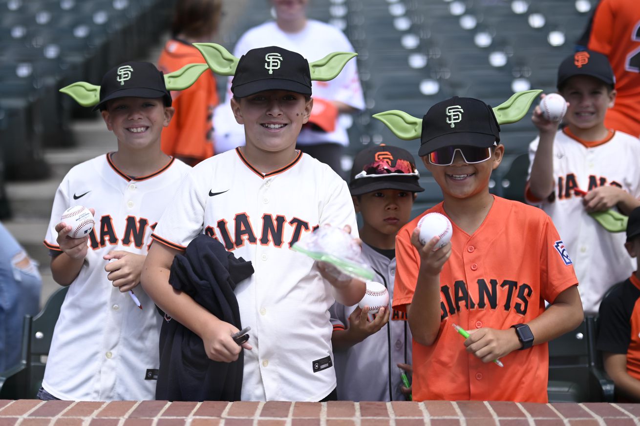 Three young Giants fans standing next to each other. 