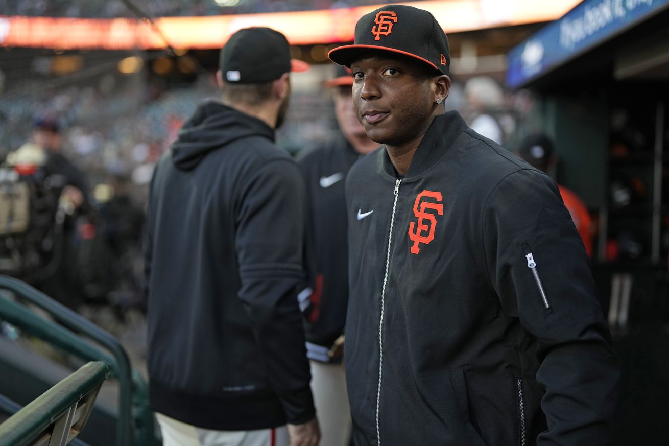 Marco Luciano wearing a jacket in the dugout. 