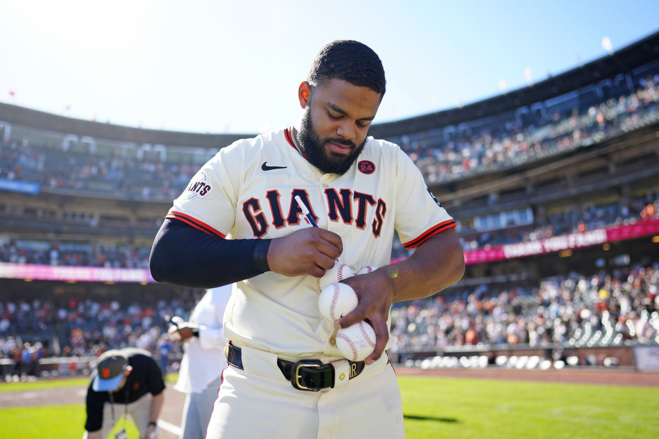 Heliot Ramos signing a baseball.