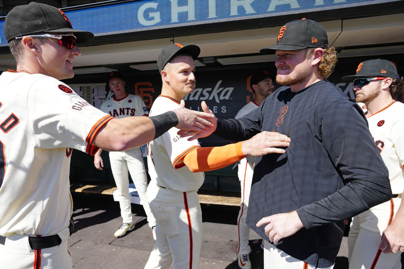 Logan Webb high-fiving Matt Chapman and Tyler Fitzgerald.