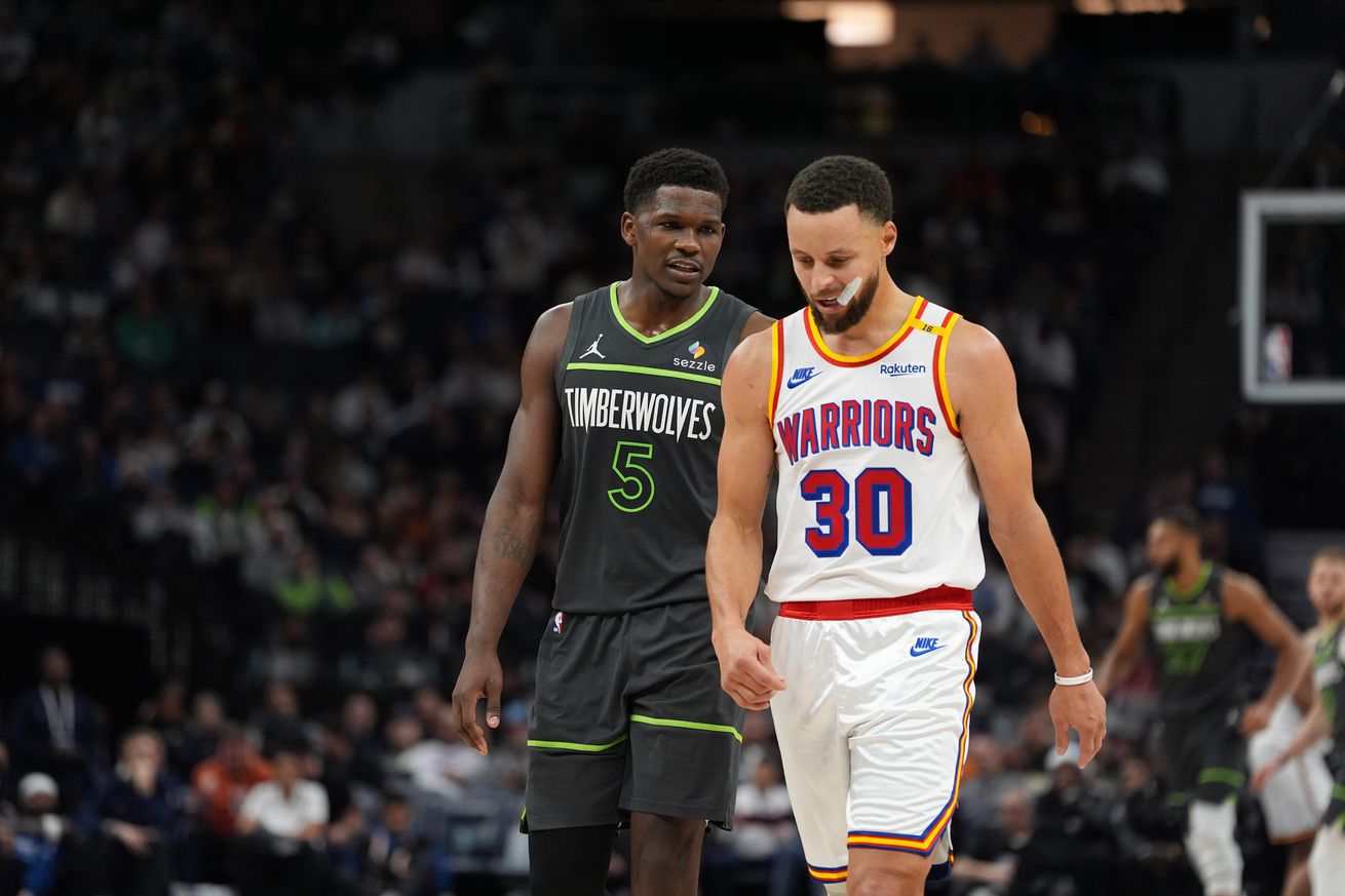 Stephen Curry standing next to Anthony Edwards. 