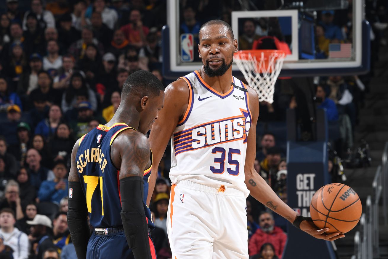 Kevin Durant holding the ball, smirking at Dennis Schröder.