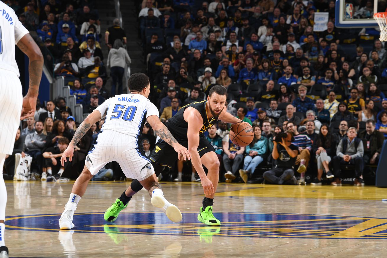 Steph Curry dribbling around Cole Anthony. 