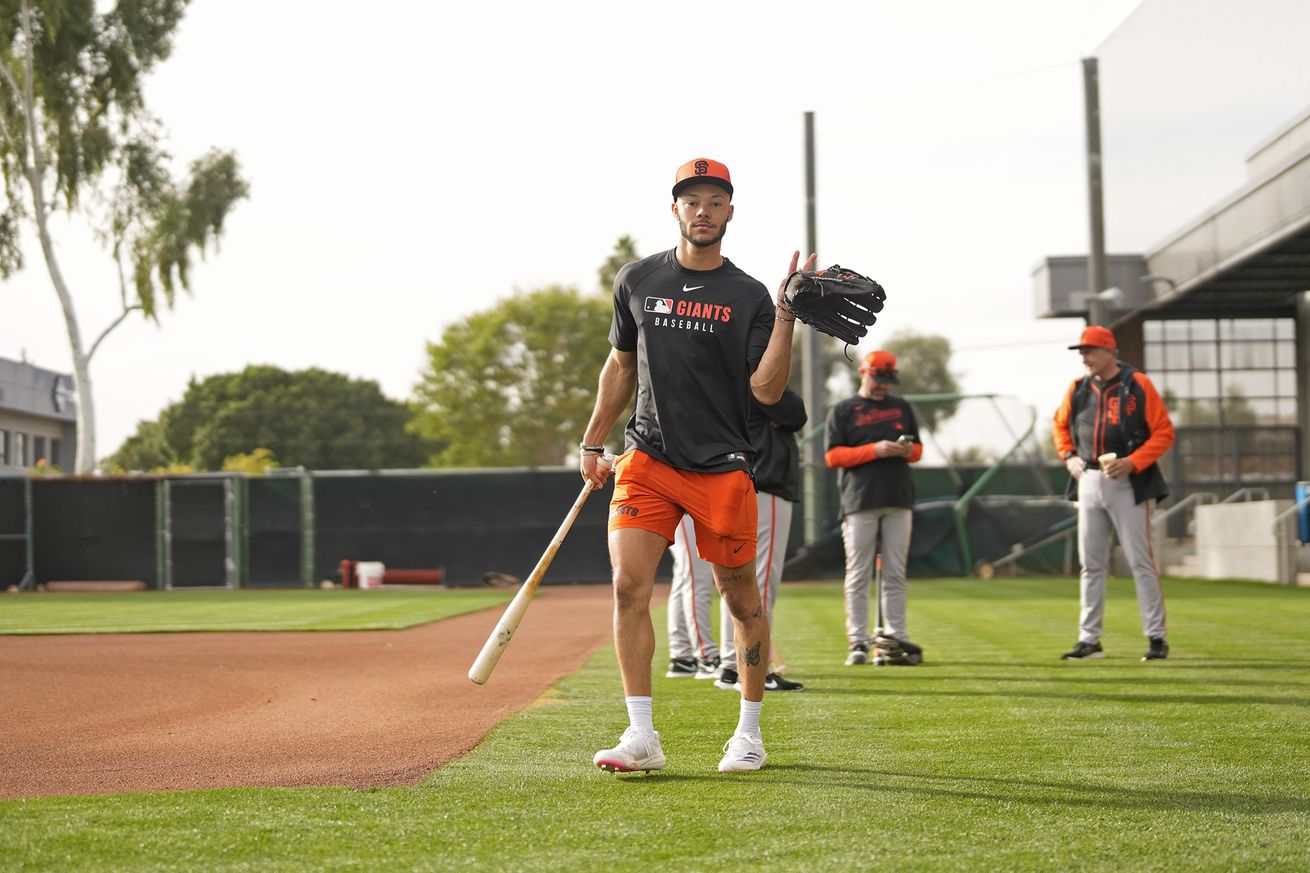 Grant McCray posing with a bat and a glove at Spring Training. 