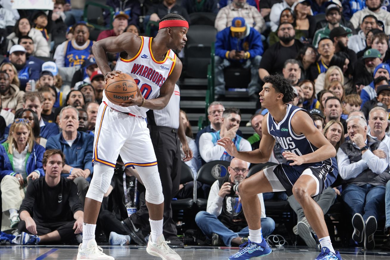 Jimmy Butler III holding the ball and facing up while defended by Max Christie. 