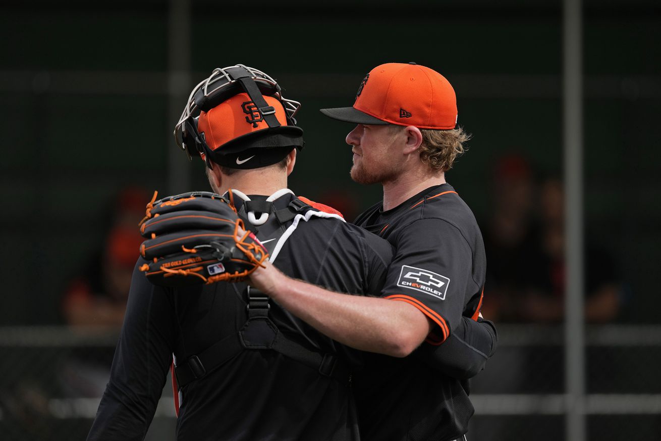 Logan Webb with his arm around a catcher at Spring Training. 