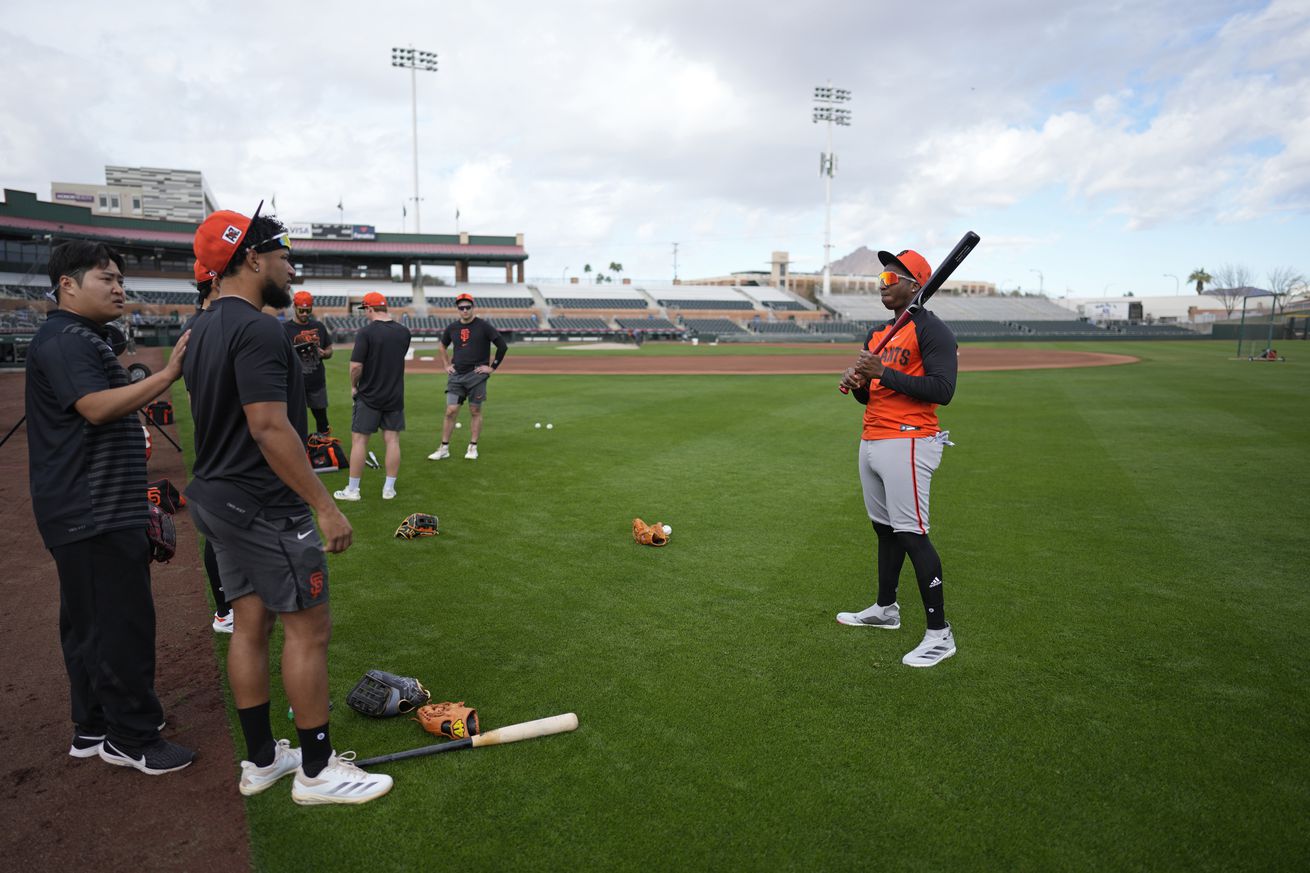 Marco Luciano standing with other Giants players at batting practice during Spring Training.