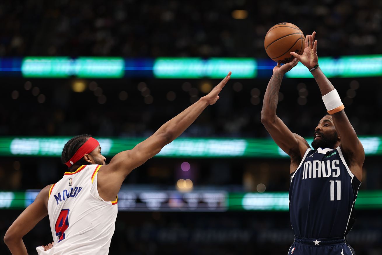 Kyrie Irving shooting a jumper over Moses Moody. 