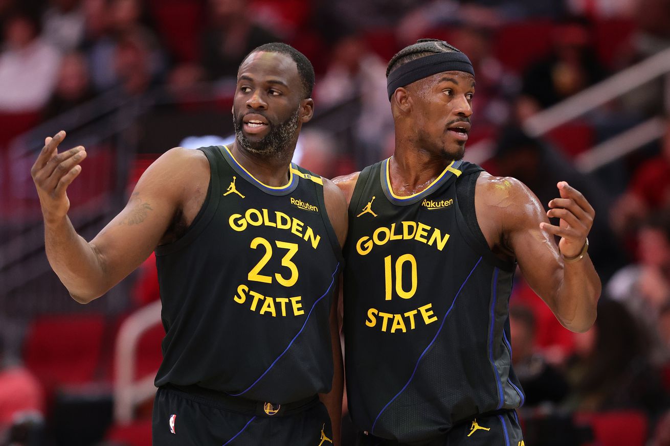 Jimmy Butler standing next to Draymond Green. 