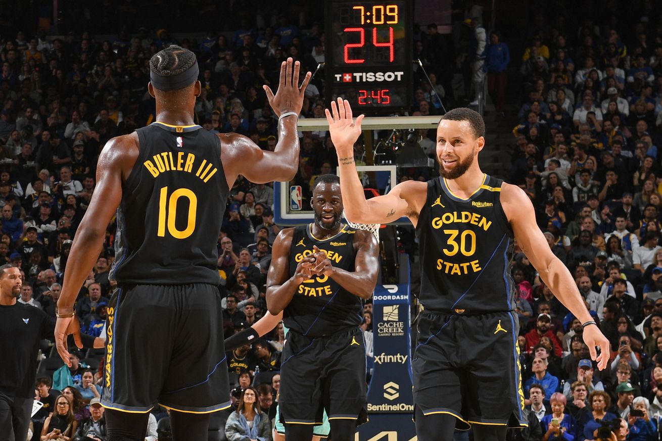 Steph Curry and Jimmy Butler III high-fiving. 