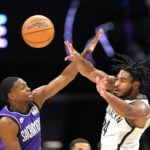 Brooklyn Nets guard Cam Thomas makes a pass while defended by Sacramento Kings guard De'Aaron Fox