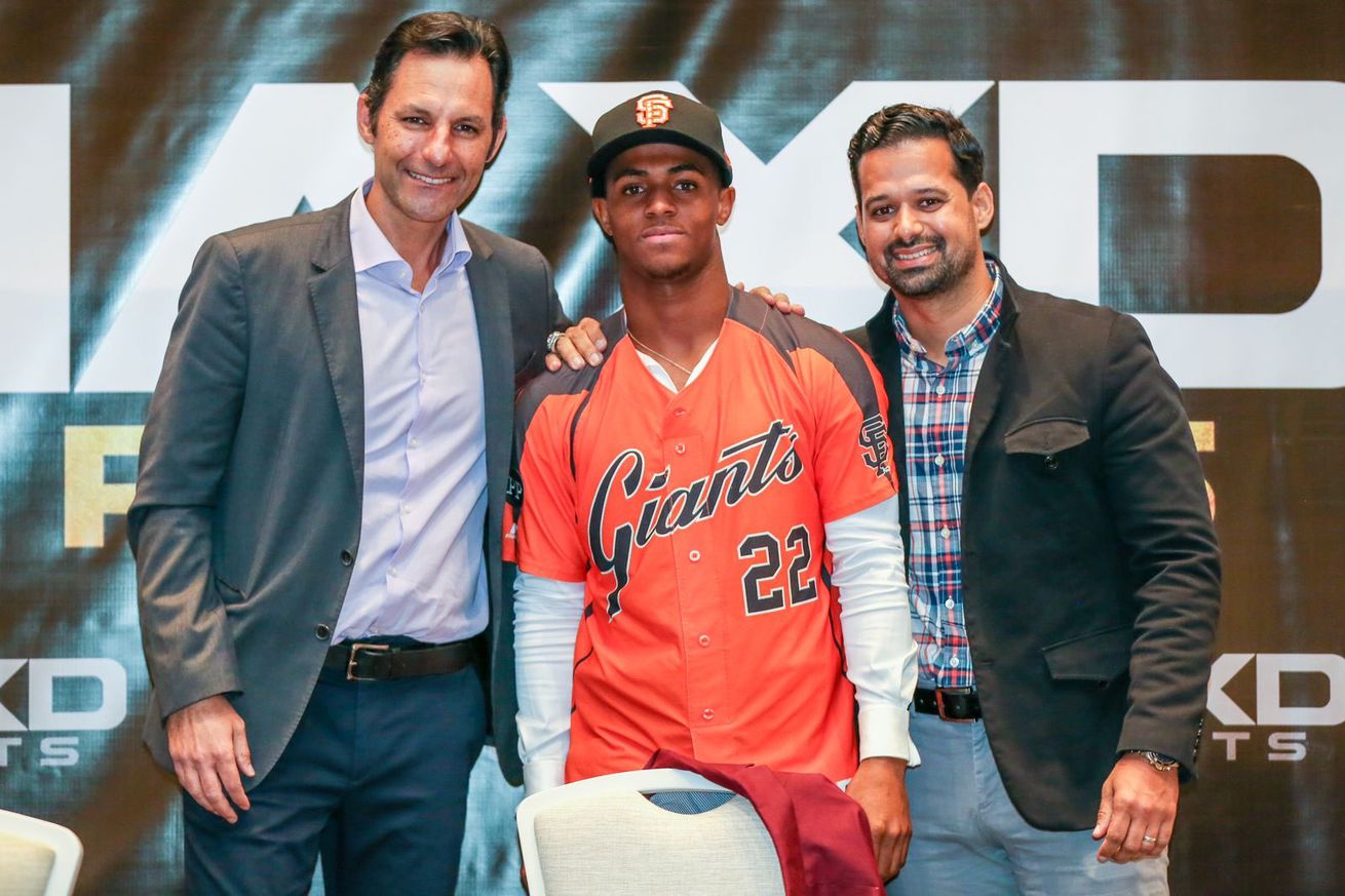 Ryan Reckley standing next to two front office members.