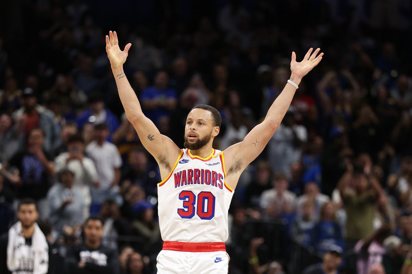 Steph Curry raising his hands in the air in celebration. 