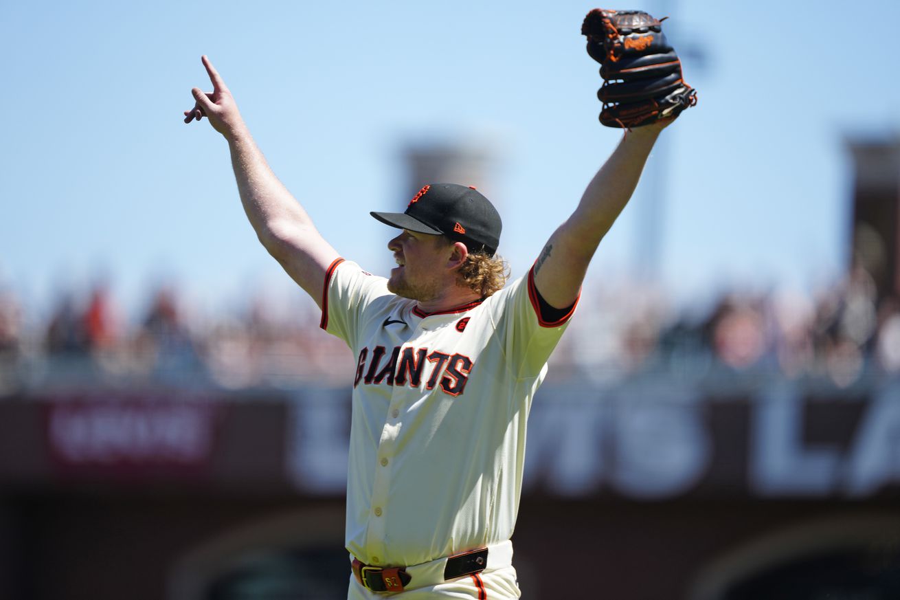 Logan Webb raising his arms in celebration. 