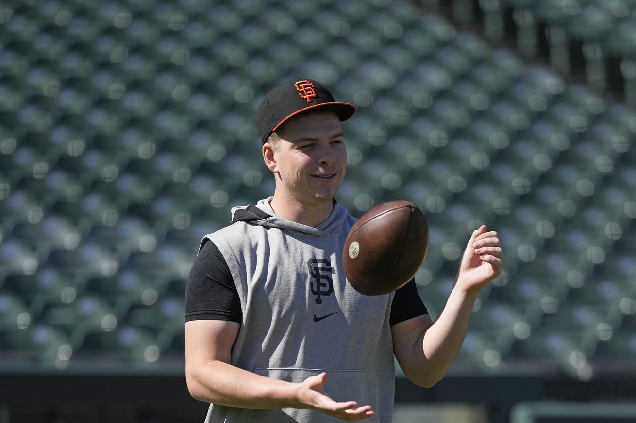 Kyle Harrison tossing a football on the field. 