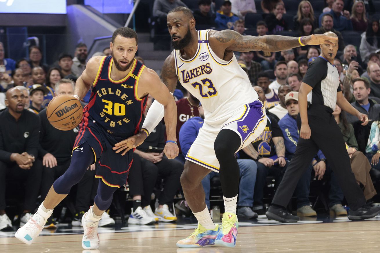 Steph Curry dribbling with his right hand around LeBron James