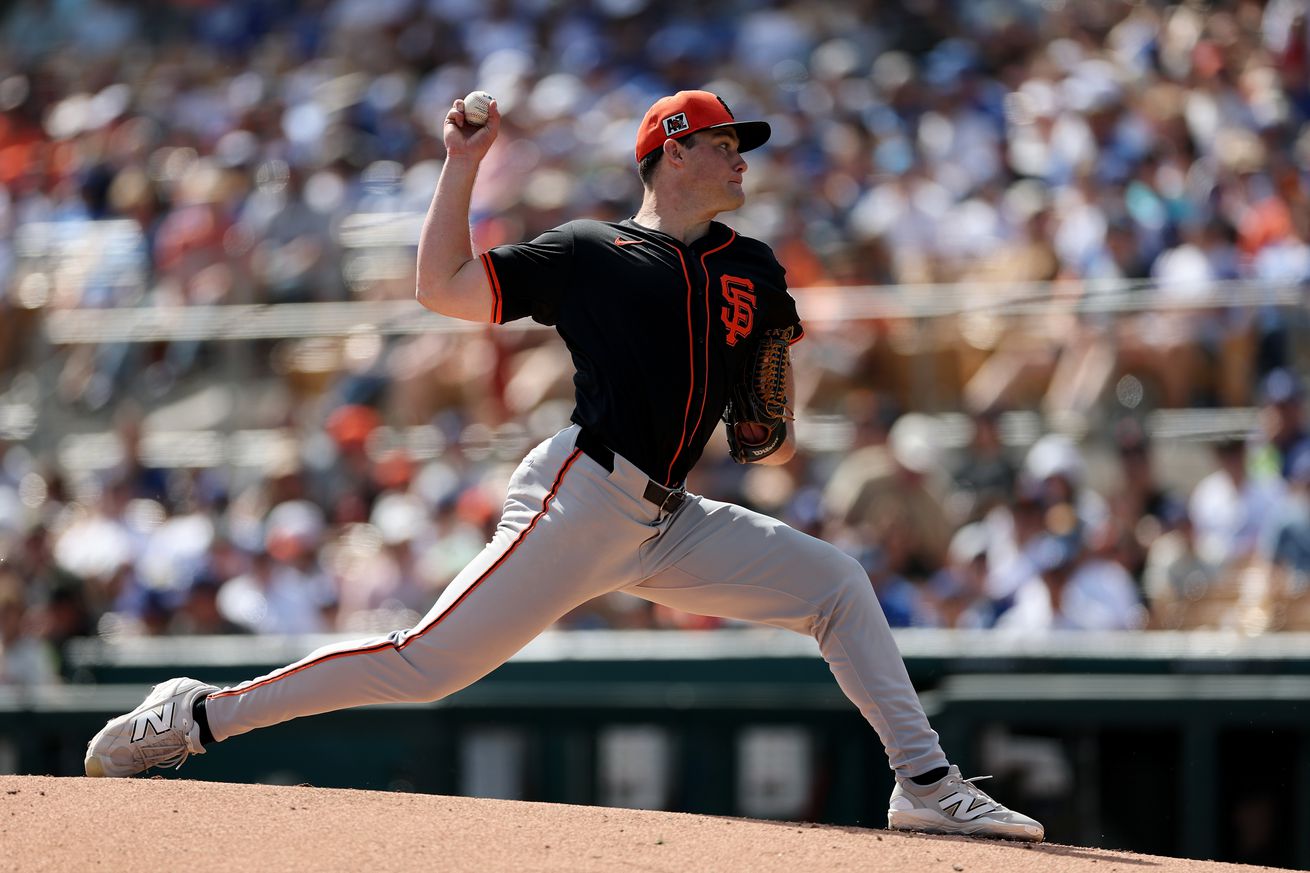 View from the side of Carson Seymour throwing a pitch. 