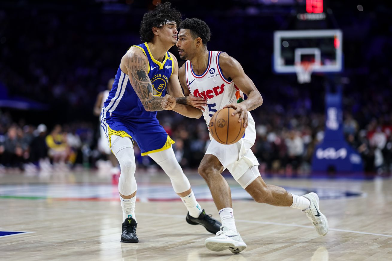 Quentin Grimes dribbling with his left hand around Gui Santos. 