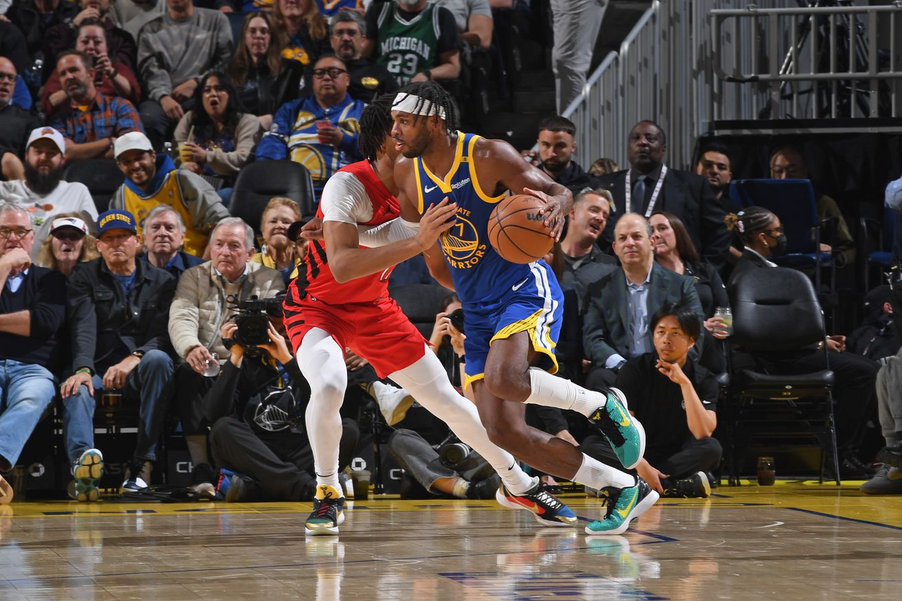 Buddy Hield dribbling around a Blazers defender. 