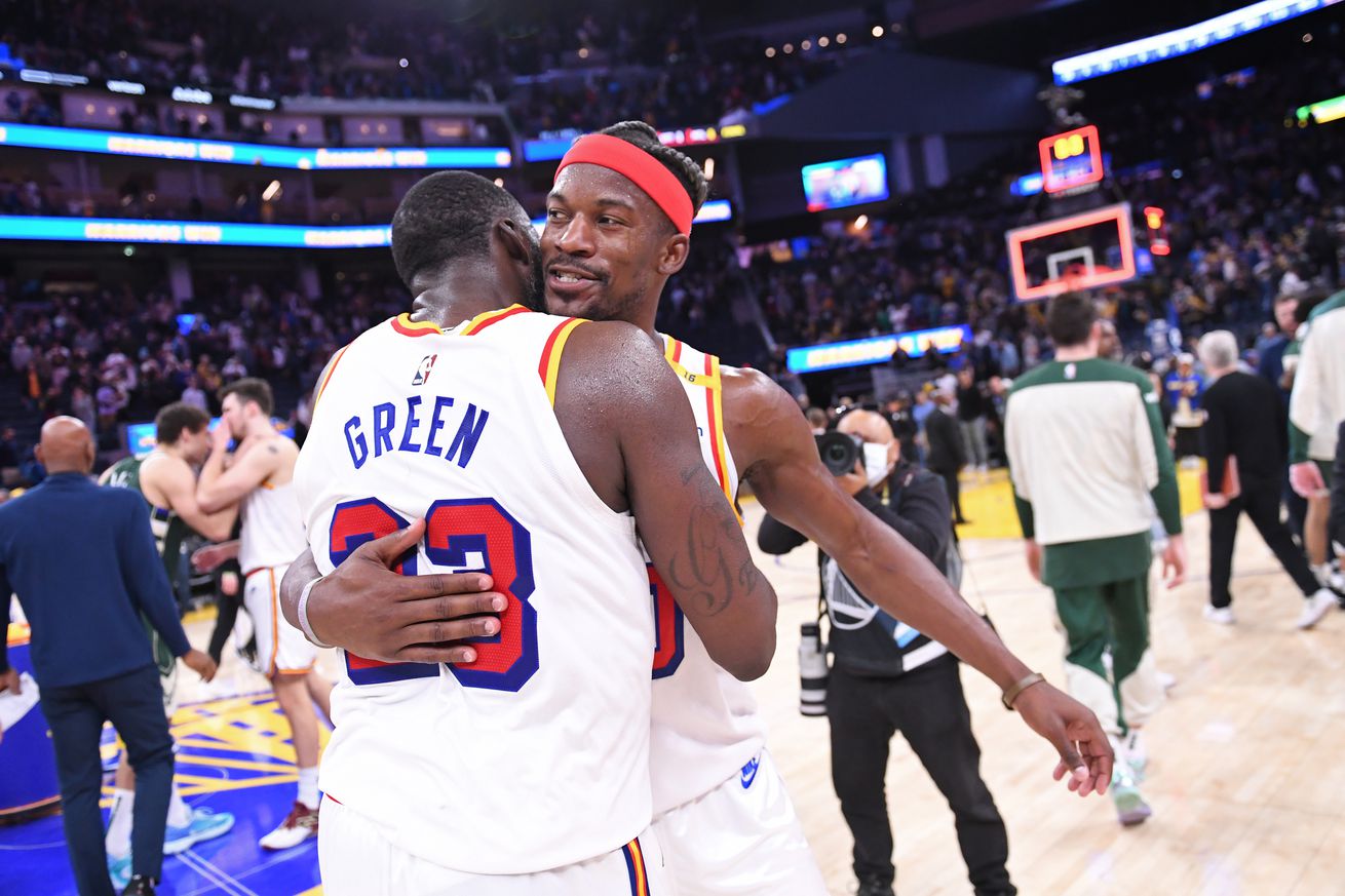 Jimmy Butler III and Draymond Green hugging on the court after a win. 