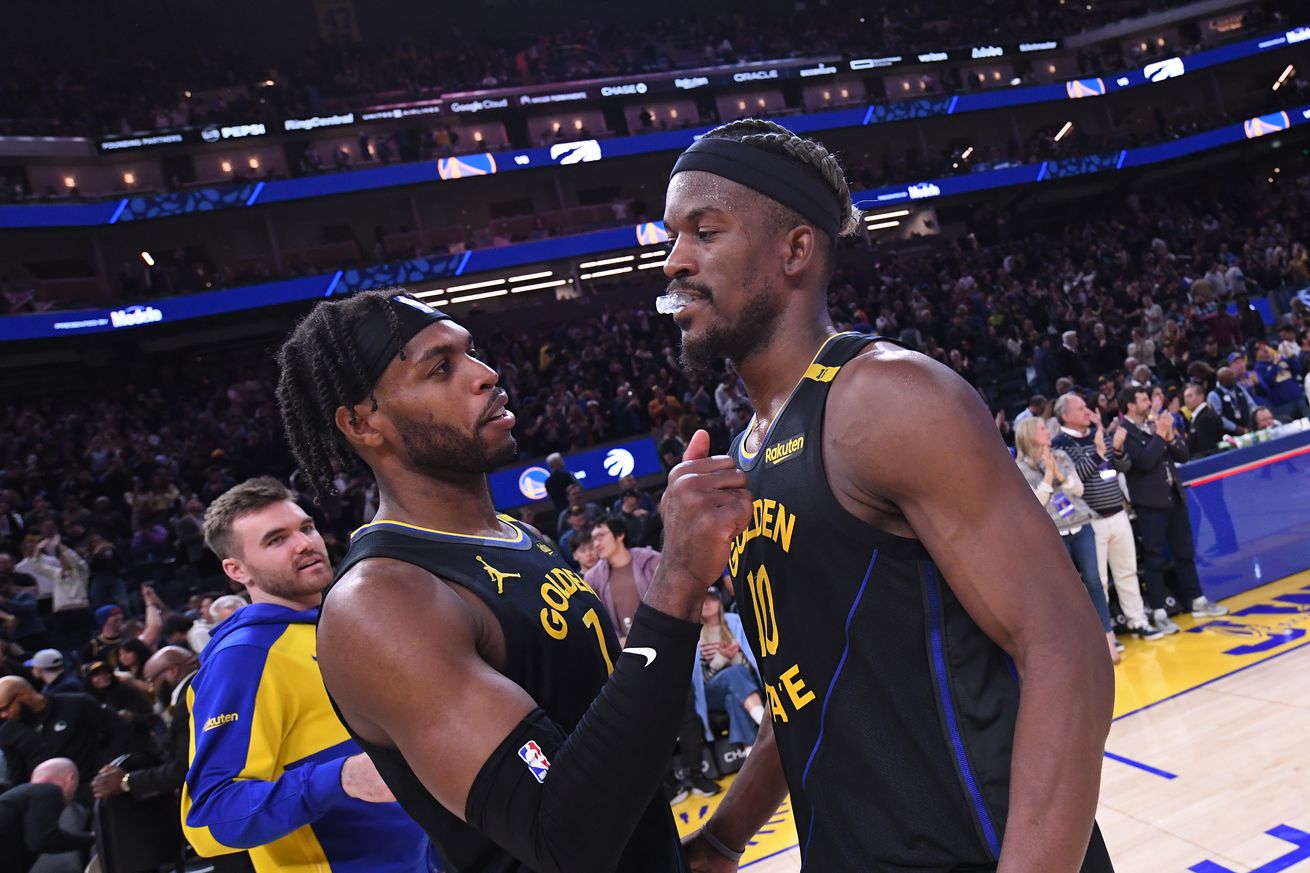 Buddy Hield patting Jimmy Butler III on the chest after a win. 