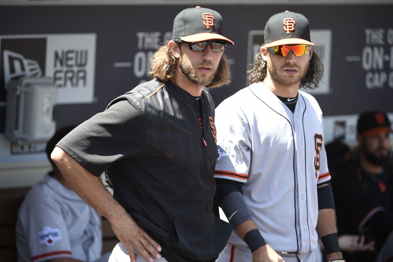 Brandon Crawford and Madison Bumgarner standing next to each other in the dugout. 