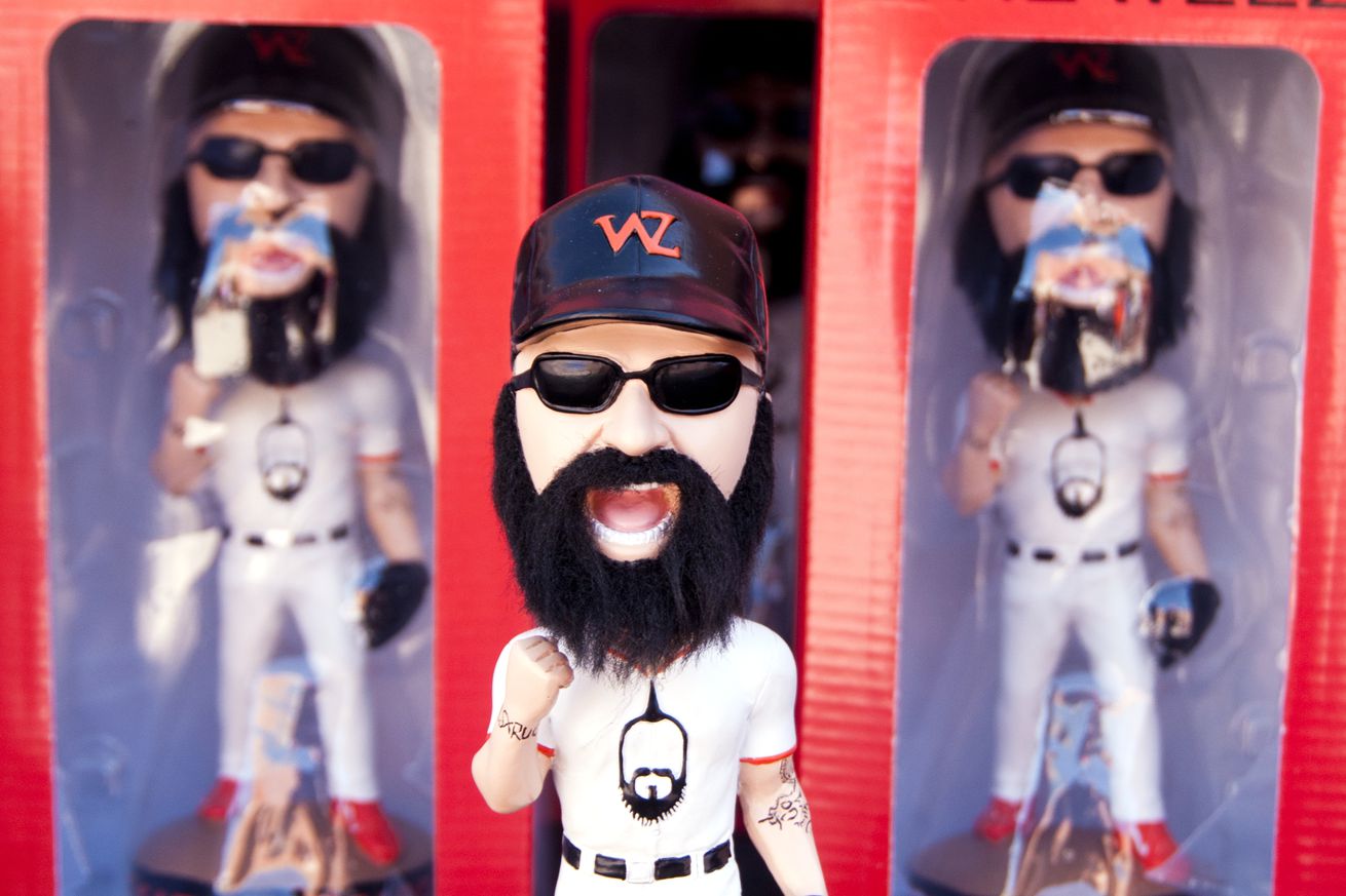 A Brian Wilson bobblehead on display with boxes of more Wilson bobbleheads behind him. 