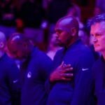 Feb 13, 2025; Houston, Texas, USA; Golden State Warriors head coach Steve Kerr (far right) and his assistant coaches stand for the national anthem before playing against the Houston Rockets at Toyota Center. Mandatory Credit: Thomas Shea-Imagn Images Jonathan Kuminga Injury